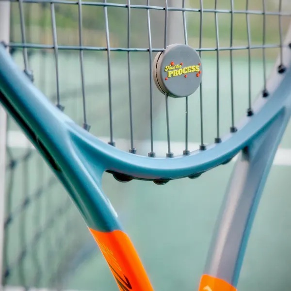 Til's Trust The Process dampener on a racket by the net